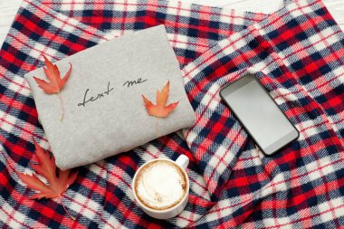 Yazıt, ekose, akıllı telefon, kapuçino kupa ve sonbahar yaprakları gri kazak. Moda kavramı