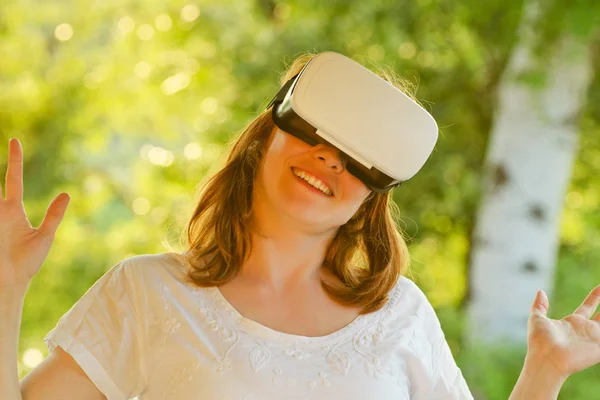 Mädchen im Helm der virtuellen Realität vor dem Hintergrund der Natur. Straffung — Stockfoto