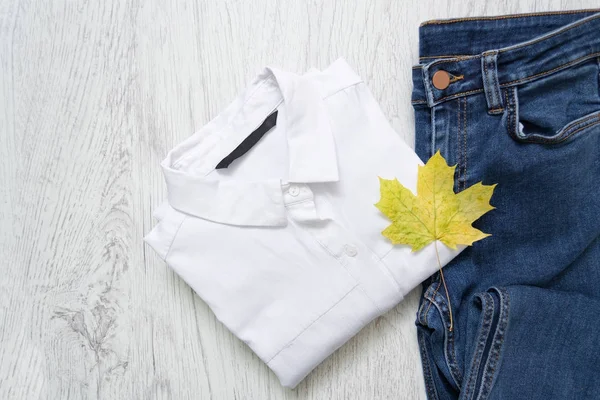 Белая рубашка, джинсы и кленовый лист. Модная концепция — стоковое фото