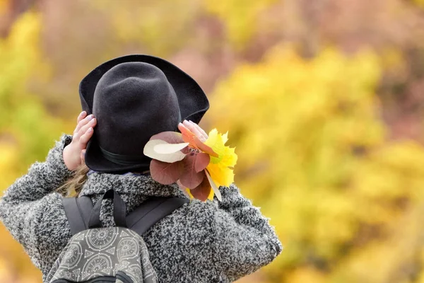 Menina em um chapéu com um buquê de folhas amarelas. Floresta de outono. Visão traseira — Fotografia de Stock