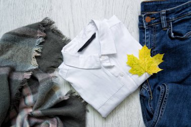 Beyaz gömlek, kot pantolon ve akçaağaç yaprağı. Moda kavramı