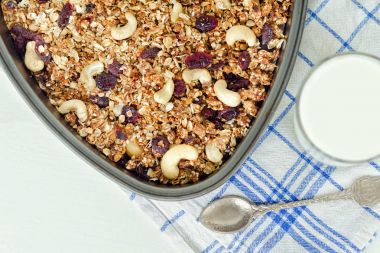 Granola bir pişirme levha ve hafif beyaz zemin üzerine yoğurt