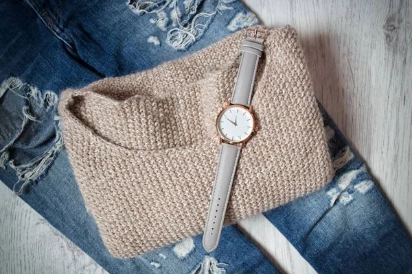 Orologio elegante su un maglione e jeans strappati. Il concetto alla moda — Foto Stock