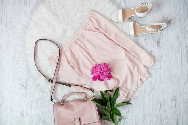 Blusa rosa, bolsa, sapatos e um peonie. Conceito na moda, pele branca no fundo — Fotografia de Stock