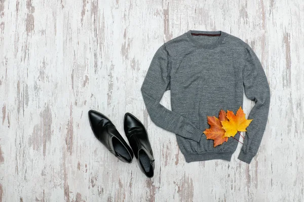 회색 스웨터, 검은 신발 및 단풍 잎입니다. 세련 된 개념. — 스톡 사진