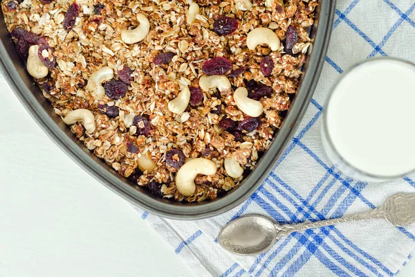 Granola bir pişirme levha ve hafif beyaz zemin üzerine yoğurt