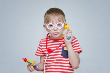 Çocuk oyun doktor. Oyuncak şırınga ve gözlük. Portre