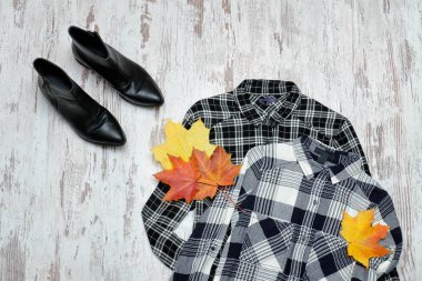 İki kareli gömlek, siyah ayakkabı ve akçaağaç yaprakları. Moda kavramı