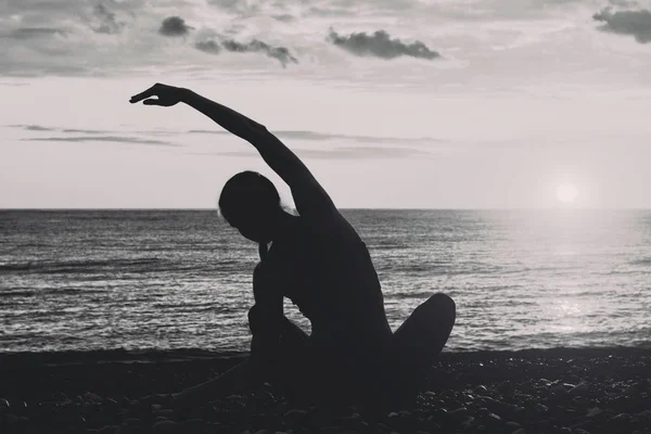 Meisje het beoefenen van yoga op het strand. Uitzicht vanaf de achterkant, silhouetten. Zwart-wit — Stockfoto