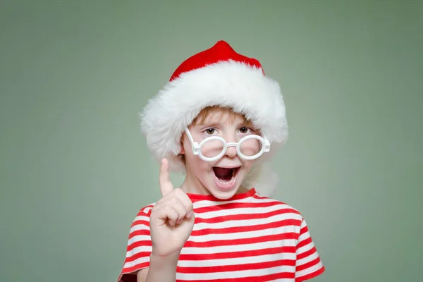 Chłopak w okularach i Santa hat grozi palcem. Portret — Zdjęcie stockowe