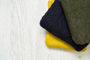 Ahşap arka plan üzerinde üç sıcak renk kazak