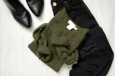 Yeşil kazak, siyah kot pantolon ve ayakkabı. Moda kavramı