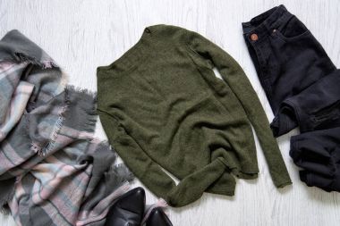 Yeşil kazak, siyah kot pantolon ve bir eşarp. Moda kavramı