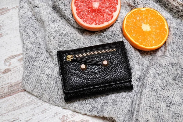 小さな黒い女性の財布とセーターを柑橘類 — ストック写真