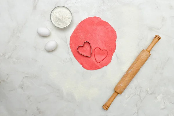 Kalpler, yumurta, un ve oklava dışarı bir kesim ile kırmızı hamur — Stok fotoğraf