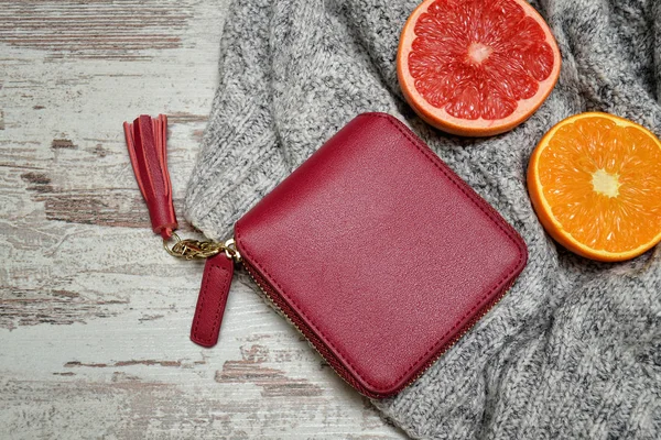 Kleine rote weibliche Handtasche und Zitrusfrüchte auf einem Pullover — Stockfoto
