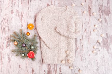 Örme kazak, bir şekilde dekore edilmiş köknar dalı ve ahşap arka plan üzerinde çelenk