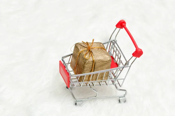 Shopping cart with gift box on white background. Holiday sale