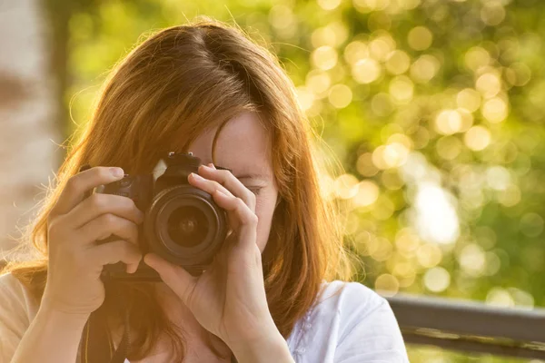 Dívka fotograf fotí na pozadí zeleně — Stock fotografie