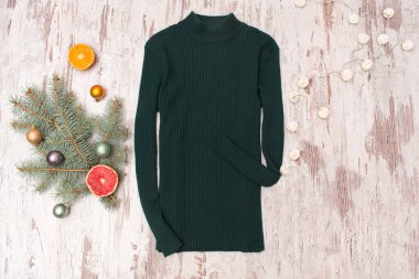 Yeşil kazak, bir şekilde dekore edilmiş köknar dalı ve çelenk