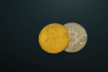 Gümüş ve altın sikke Bitcoin üzerinde siyah bir arka plan. İzole.