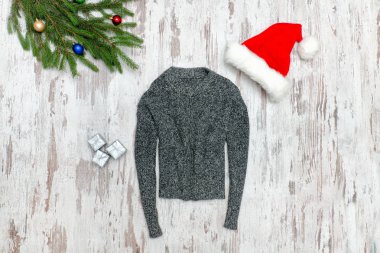 Gri kazak, Noel Baba'nın şapka ve köknar dalı ahşap arka plan üzerinde.