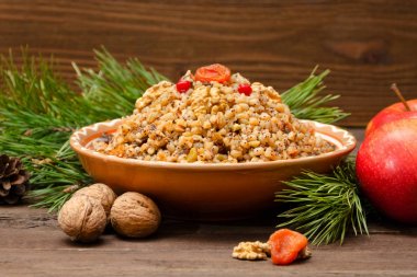 Geleneksel Slav tabak kahverengi ahşap masa üzerinde Noel arifesinde tedavi. Çamın dalları, elma, ceviz. Portre