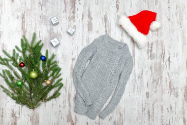 Gri kazak, Noel Baba'nın şapka ve köknar dalı ahşap arka plan üzerinde.