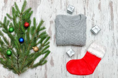Kırmızı Noel çorap ve gri kazak. Süslü çam dalı