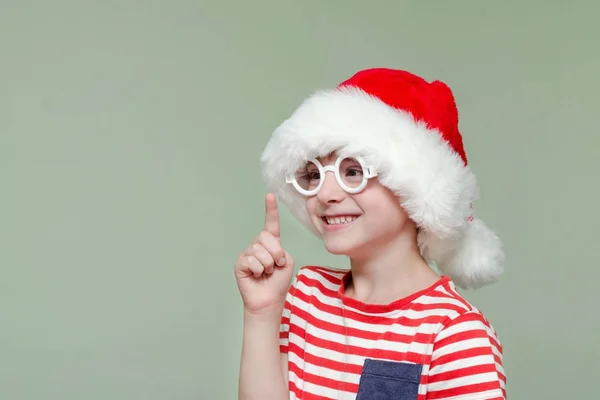 Roześmiany chłopiec w santa kapelusz i okulary grozi palcem — Zdjęcie stockowe