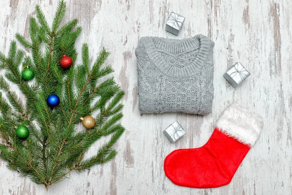 Kırmızı Noel çorap ve gri kazak. Süslü çam dalı