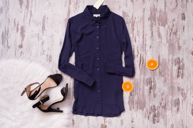 Mavi gömlek, siyah ayakkabı, beyaz kürk ve narenciye