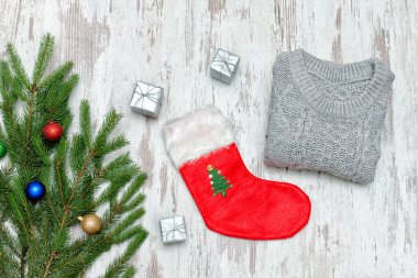Kırmızı Noel çorap ve gri kazak. Süslü çam dalı