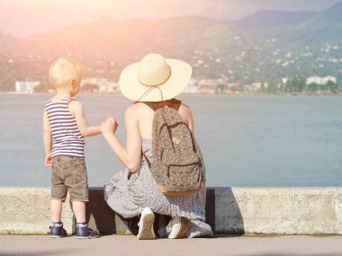 Anne ve oğlu deniz arka planda, iskelede deniz feneri