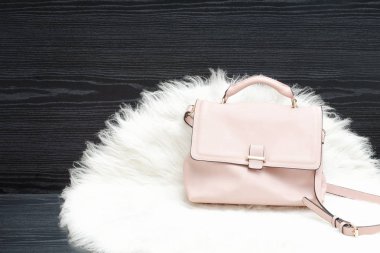 Pembe çanta beyaz kürk, siyah masada. Moda kavramı