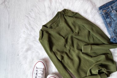 Haki kazak, kot pantolon ve beyaz spor ayakkabı. Moda kavramı