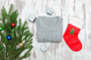 Kırmızı Noel çorap ve gri kazak. Süslü çam dalı