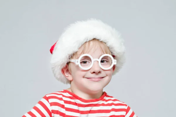 Uśmiechnięty chłopiec w Santa's kapelusz i okulary. Portret — Zdjęcie stockowe