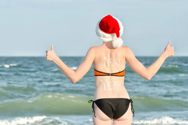 Mädchen in Weihnachtsmützen mit der Aufschrift Neujahr auf der Rückseite — Stockfoto