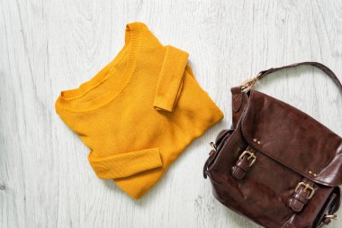 Turuncu kazak ve kahverengi çanta. Moda kavramı