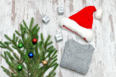 Noel Baba şapkası, köknar dalı ve ahşap arka plan üzerinde gri kazak ile dekore edilmiş