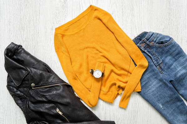 Orange sweater, watch, black jacket and jeans