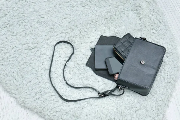 Açık siyah çanta bırakılan şeyler, dizüstü bilgisayar, cep telefonu ve cüzdanı. Arka plan üzerinde kürk. Moda kavramı — Stok fotoğraf