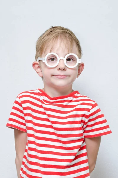 Un chico con una camiseta a rayas y gafas. Cara inteligente —  Fotos de Stock