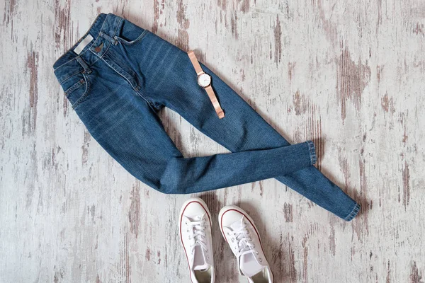 Blue jeans, horloge en witte sneakers op houten achtergrond. Modieuze concept — Stockfoto