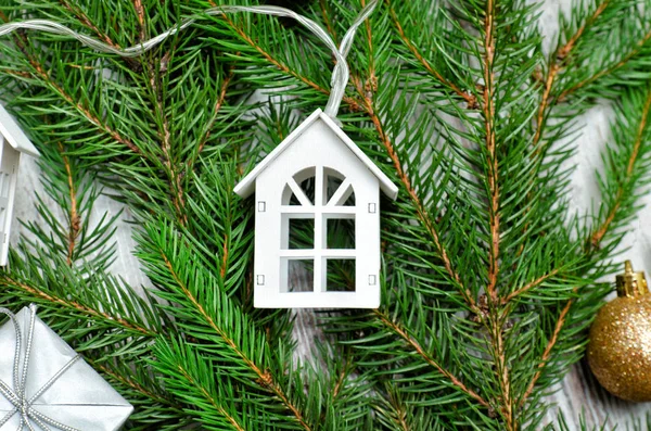 Decorated fir branch and small white house. Holiday concept