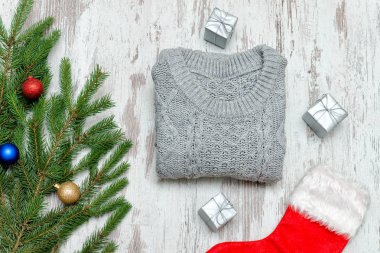 Kırmızı Noel çorap ve gri kazak. Süslü çam dalı