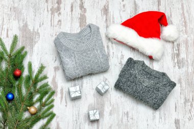 İki gri kazak, Noel Baba'nın şapka ve köknar dalı ahşap arka plan üzerinde