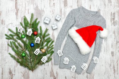 Gri kazak, Noel Baba'nın şapka ve köknar dalı ahşap arka plan üzerinde.