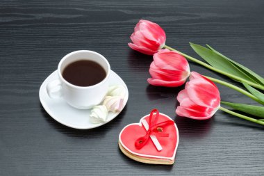 Bir fincan kahve ve heartshaped gingerbread, üç Pembe Laleler